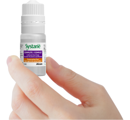 Image of a hand with a bottle of Systane Complete PF