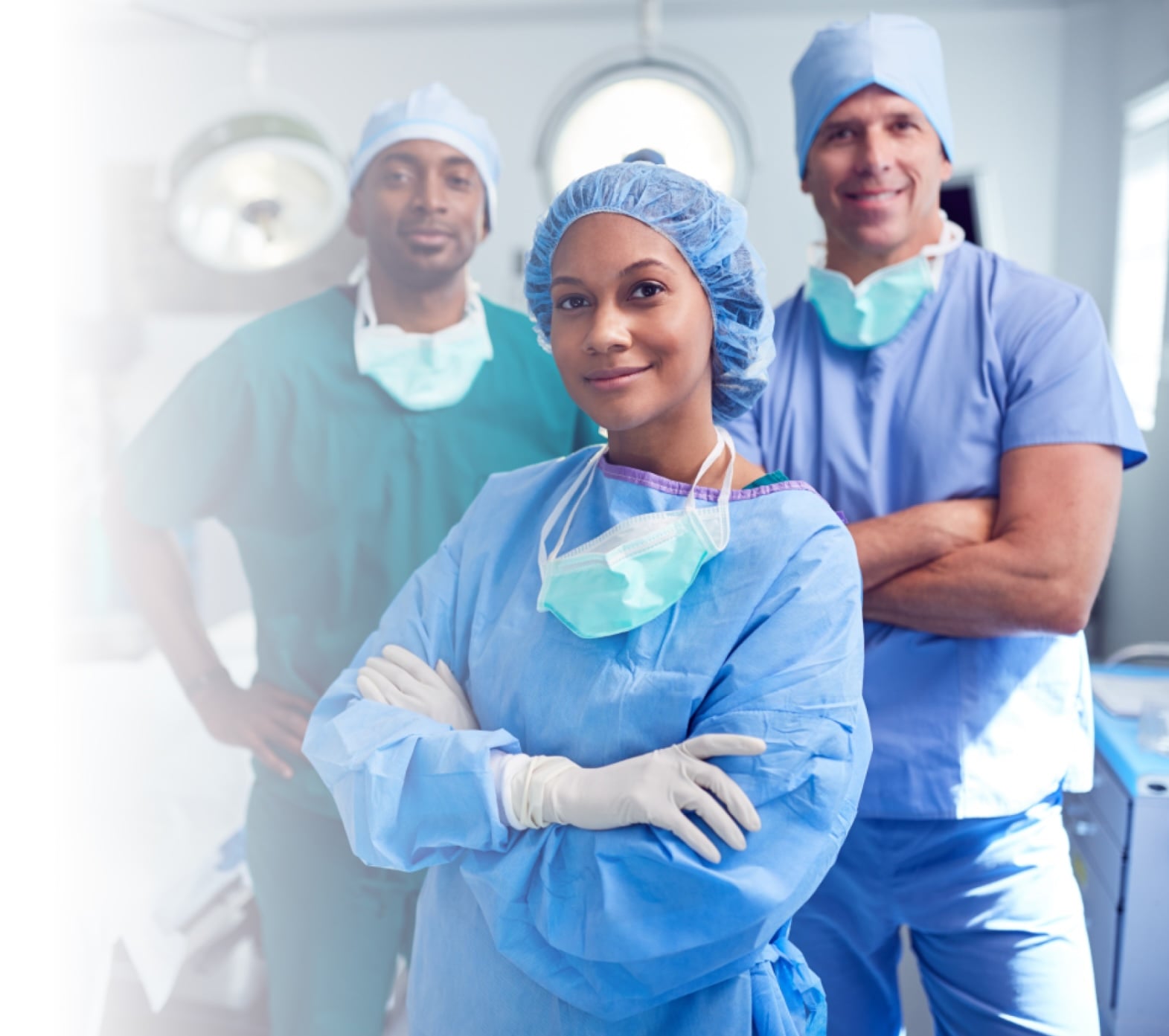 An image of three smiling surgeons wearing surgical scrubs in the operating room. 