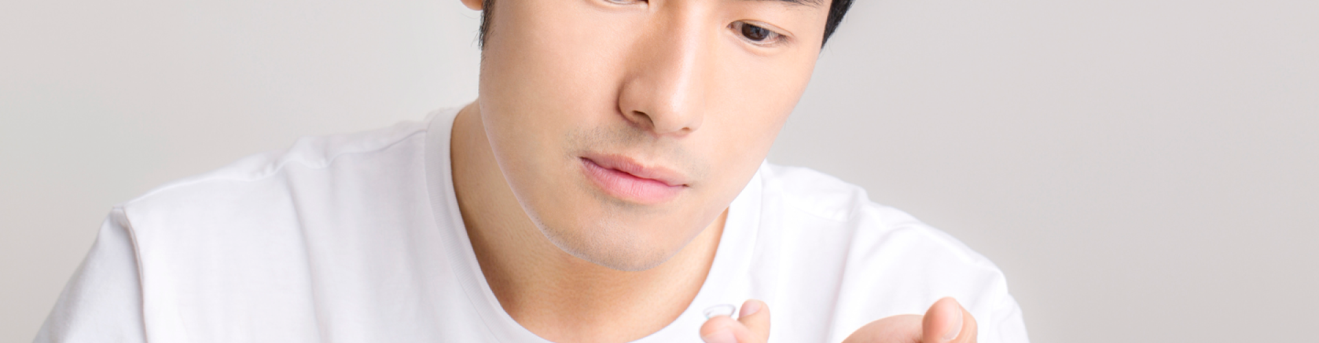Man with contact lens on finger