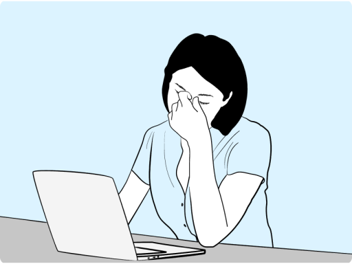 Woman at computer rubbing eyes