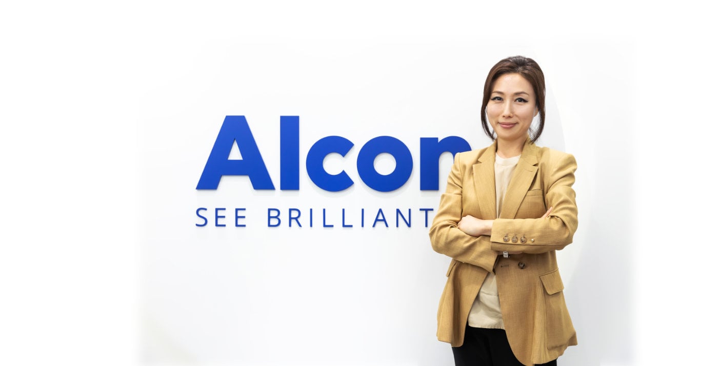 Nicole Bang standing next to Alcon sign
