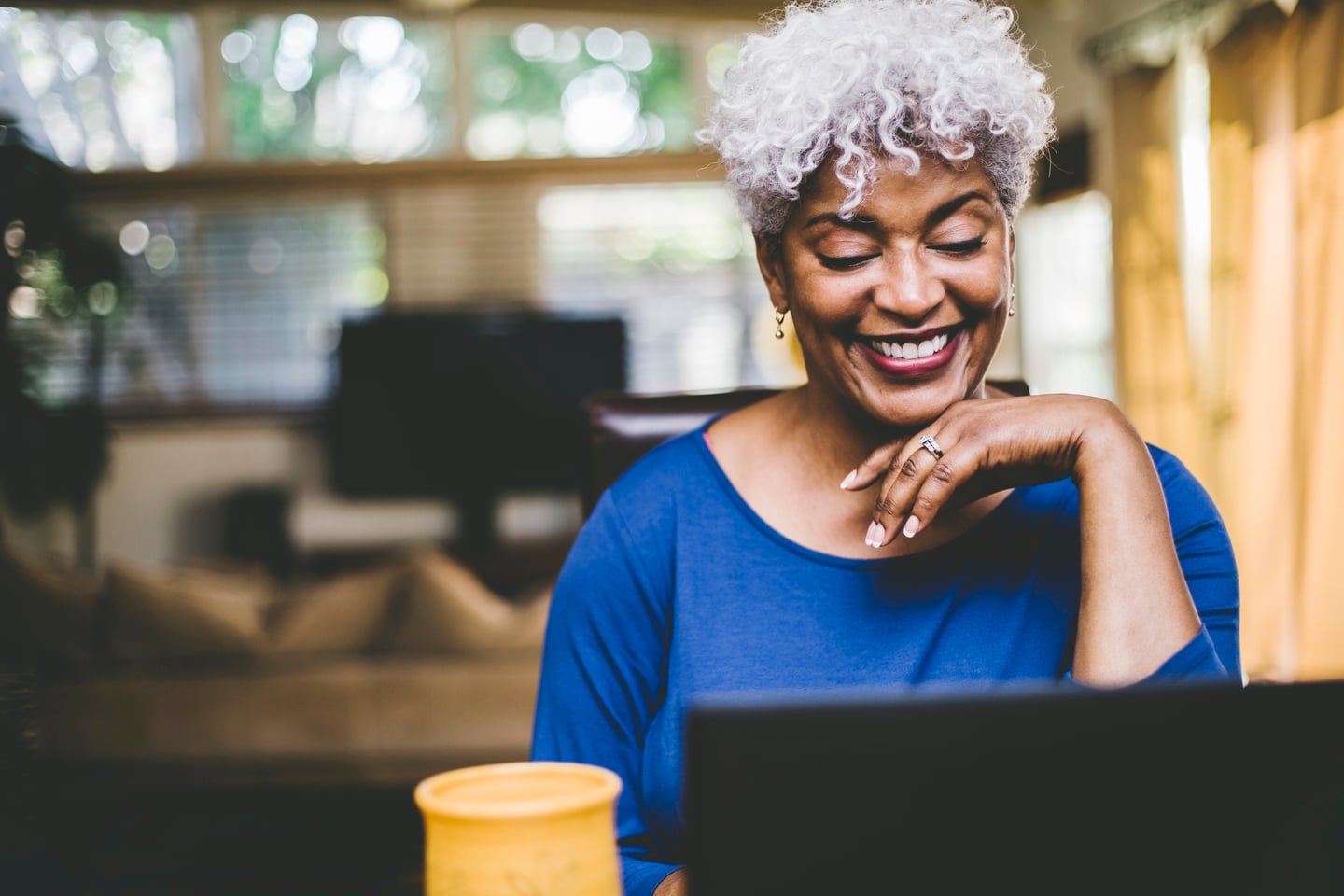 Woman smiling and working on laptop computer
