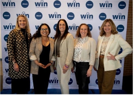 Group of women standing in front of Alcon WIN background