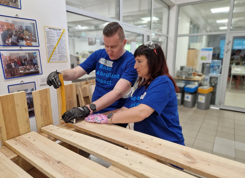 Alcon volunteers in blue t-shirts building shelving