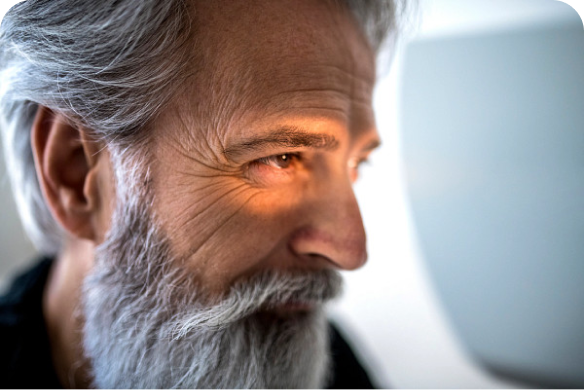 Man smiling into eye examination device