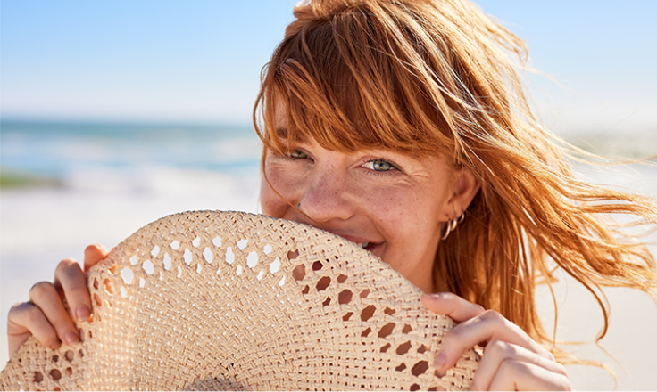 Woman with a hat on the beach